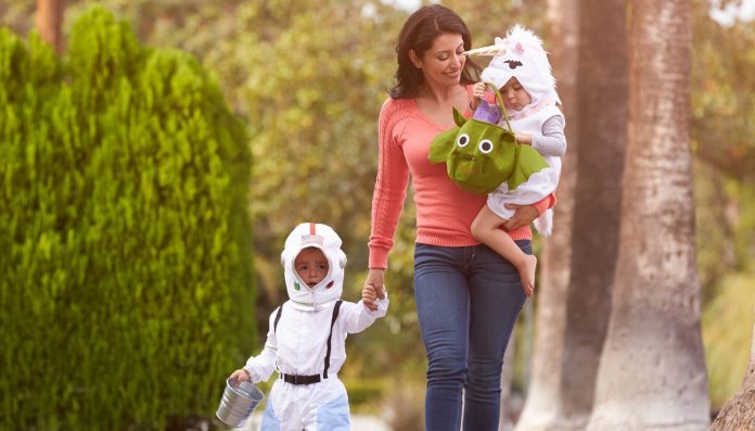 Parent Taking Children Trick Or Treating At Halloween